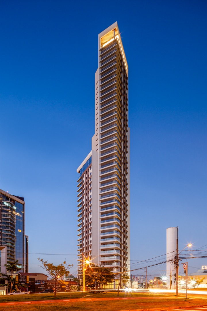 Torre residencial de alto padrão iluminada ao entardecer